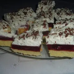 Pyszne ciasto wiśniowa fantazja z puszystą bitą śmietaną i czekoladowymi wiórkami, gotowe do podania.