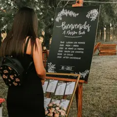 Cartel sobremesa de bienvenida a una boda con horarios y nombres de los novios.