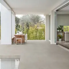 Terrazza con piscina e cucina moderna, pavimentata in gres materiale che si estende all'esterno.