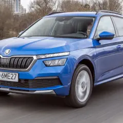Niebieska Skoda Kamiq w ruchu drogowym. Kierowca za kierownicą. Wiele pozytywnych skoda kamiq opinie potwierdza jej wszechstronność.