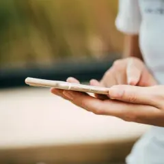 Mani che scorrono su uno smartphone dorato. Come in un ciclo, chi fa orbiting ritorna sempre a connettersi.