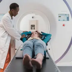 Lekarka przygotowuje pacjentkę do badania rezonansem. Częstotliwość badań zależy od wskazań medycznych.
