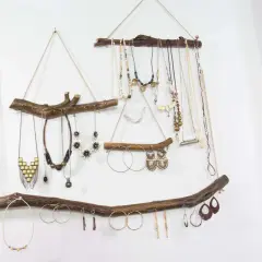Colgante rústico con ramas de madera, ideal para exhibir collares y pendientes. Un ejemplo de manualidades de madera para adultos, con un toque bohemio.