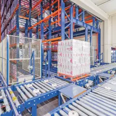 Automatyczny magazyn z systemem przenośników taśmowych i paletą towarów.