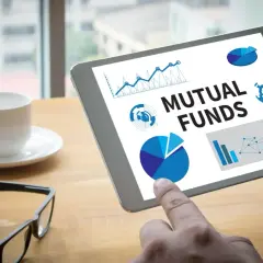 Tablet zeigt "Mutual Funds" mit Diagrammen. Ein Finger tippt auf den Bildschirm, während eine Kaffeetasse und Brille daneben liegen. Der **Ausgabeaufschlag Fonds** wird analysiert.