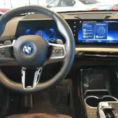 Wnętrze BMW X1 z nowoczesnym ekranem i kierownicą. Sprawdź aktualną bmw x1 cena i wyposażenie.