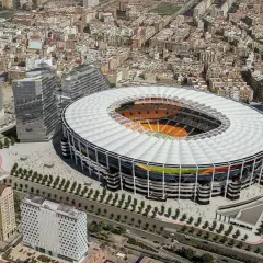 Nowoczesny walencja stadion otoczony miejską zabudową, z widocznym boiskiem i trybunami.