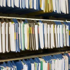Rzędy wiszących segregatorów i teczek tworzą uporządkowany system plików.