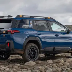 Niebieski Subaru Outback 2026 na kamienistym, górzystym terenie, gotowy na przygodę.
