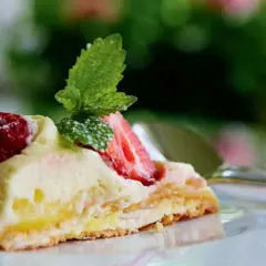 En bit pavlova med lemoncurd, toppad med färska jordgubbar och mynta. En härlig dessert som smälter i munnen.