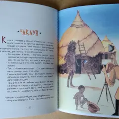 Afryka Kazika streszczenie: czarownik z plemienia Abasalamaps opowiada o swoich amuletach i mocy. Na ilustracji widać wioskę, czarownika i fotografa.