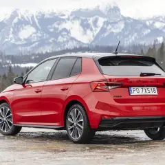Czerwona Skoda Fabia Monte Carlo z czarnym dachem na tle ośnieżonych gór.