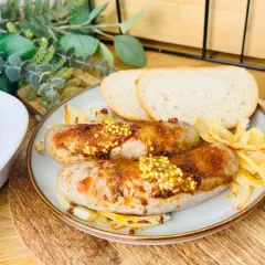 Pyszna, pieczona kiełbasa biała z musztardą i cebulką, podana z chlebem. Idealna na obiad.