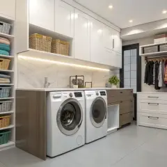 Aménagement buanderie moderne avec lave-linge, sèche-linge, étagères remplies de paniers et de linge plié, et un portant avec des vêtements.