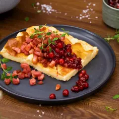 En bit ugnspannkaka med knaperstekt bacon och rårörda lingon, garnerad med färska örter. En klassisk svensk rätt som väcker aptiten.