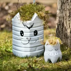 Urocze dekoracje ogrodu DIY w kształcie kotków, wykonane z recyklingu, dodają uroku zielonej trawie.
