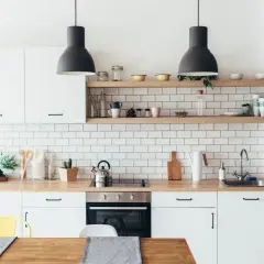 Nowoczesna kuchnia w mieszkaniu 40m2 rzut. Białe płytki, drewniany blat, czarne lampy.