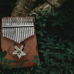 Drewniana kalimba z metalowymi klawiszami, ozdobiona motywem jelenia i kwiatu. To instrument, który zachwyca dźwiękiem.