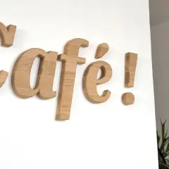 Une belle lettre en bois "Café !" orne le mur blanc, invitant à la détente.