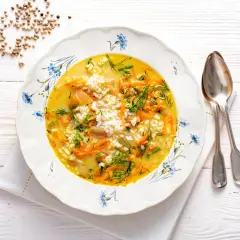 Aromaticzna zupa koperkowa z ryżem, marchewką i zielonym koperkiem, podana w ozdobnym talerzu.