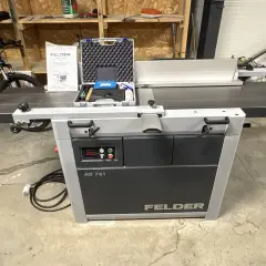 Rabot dégau Felder AD 741, prêt à l'emploi dans un atelier. Un vélo est garé à proximité.