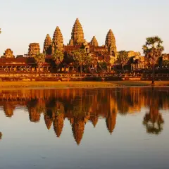 Angkor Wat au coucher du soleil, un incontournable pour savoir que faire au Cambodge. Les tours se reflètent dans l'eau.