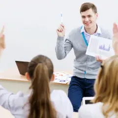 Lehrer erklärt den Unterschied zwischen dualem und berufsbegleitendem Studium. Schüler melden sich.