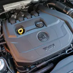 Motor 1.5 TSI 150cv, con su tapa negra y logo Skoda. Se aprecian manguitos y depósito de refrigerante.