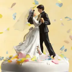 Statua di sposi su torta nuziale, con coriandoli colorati che volano. 75 anni di matrimonio, che nozze sono!