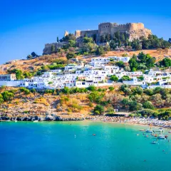 Lindos auf Rhodos: weiße Häuser, Burgruine und ein belebter Strand. Tolle Rhodos Urlaub Tipps für deine Reise!
