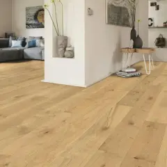 Un soggiorno moderno con parquet chiaro. Un divano grigio e un tavolino completano l'arredamento. Immagine che illustra come si monta il parquet.