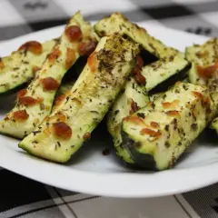 Delicioso calabacín al horno, cortado en bastones y cubierto con queso derretido y hierbas aromáticas.