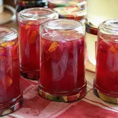 Słoiki z kompotem z rabarbaru i płatkami róży. Idealny sposób, by zachować smak lata i wiedzieć, co zrobić z rabarbaru na zimę.
