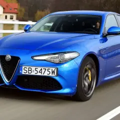 Niebieskie Alfa Romeo Giulia w ruchu, z widocznymi detalami, które mogą być interesujące dla osób szukających informacji o alfa romeo giulia dane techniczne.