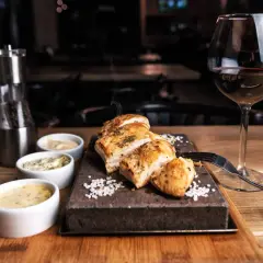 Un plat de poulet grillé avec trois sauces, du sel, un moulin à poivre et un verre de vin rouge. La question est : quel vin avec viande blanche ?