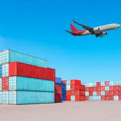 Frachtflugzeug über Containerstapeln. Die IATA Bedeutung für globalen Handel wird hier visuell dargestellt.
