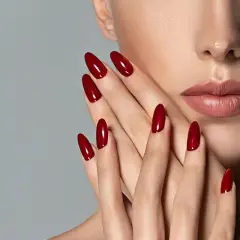 Mani eleganti con unghie a mandorla color rosso ciliegia, perfette per una durata semipermanente impeccabile.