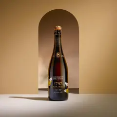 Eine Flasche "1797 C-Bratbirne" von Manufaktur Jörg Geiger, eine edle Champagner Alternative, steht im Scheinwerferlicht.