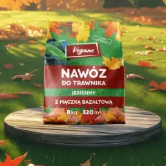 Opakowanie nawozu do trawnika Vegano jesienny na tle trawnika z opadłymi liśćmi.