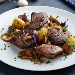Pyszna wątróbka z indyka z ziemniakami, cebulką i grzybami, posypana szczypiorkiem.