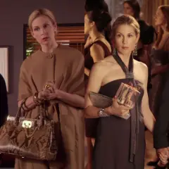Lily van der Woodsen och hennes familj på en tillställning. En ung man, Lily i en beige kappa, och ett par som håller varandra i handen.