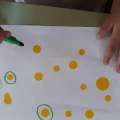 Manos de niño creando círculos y puntos, inspirándose en las kandinsky obras para niños.