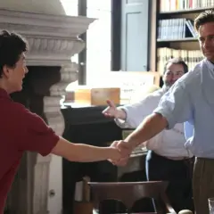 Elio und Oliver schütteln sich die Hände, ein Moment, der an "Call Me By Your Name 2" erinnert. Ein Mann im Hintergrund lächelt.