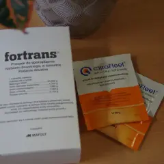 Opakowanie leku Fortrans i saszetki CitraFleet, które pomagają w przygotowaniu roztworu doustnego.