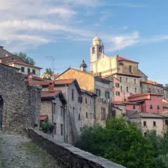 Antico borgo in pietra della Lunigiana, dove si trova un'antica porta d'accesso e una chiesa con campanile.