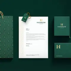 A sophisticated brand identity featuring a monogram logo with the letter "H" on a shopping bag, stationery, and packaging.