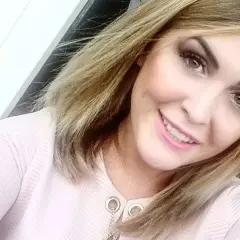 Uśmiechnięta Magdalena Pyznar w różowej bluzce z ozdobnym łańcuszkiem.