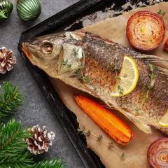 Pieczona ryba z cytryną, marchewką i cebulą na świątecznym stole. Czy ryba to mięso? To pytanie, na które każdy odpowie inaczej, ale ta potrawa z pewnością jest pyszna!