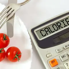 Pomidorki i kalkulator z napisem "CALORIES". Czy na keto trzeba liczyć kalorie? To pytanie zadaje sobie wiele osób.