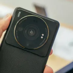 Dłoń trzyma czarny telefon Xiaomi z dużym modułem aparatu Leica.